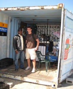 Project team member, Mike Fitzpatrick, poses with a cell phone service and repair shop owner in C section, Monwabisi Park.