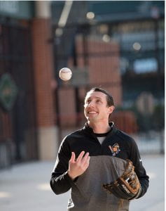 Joseph Botehlo in an Orioles shirt tosses a baseball in the air