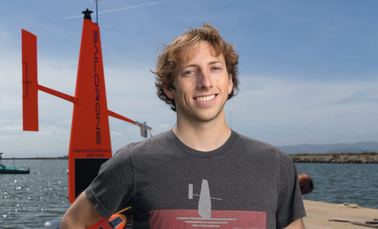 Casey Brown in front of Saildrone's sea-exploring drones