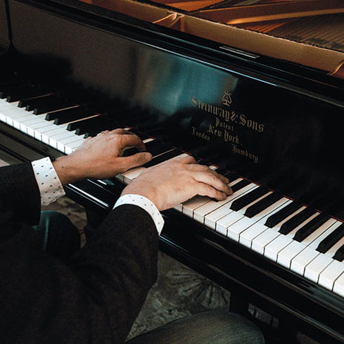 Sergio Salvatore's hands on the keys of his grand piano