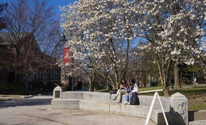 Two students enjoy a pretty spring day on campus
