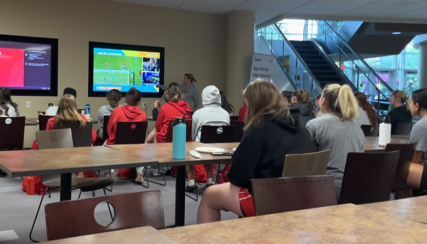 The women's soccer team watches the 2023 Women's World Cup to catch a glimpse of Gabi Hoops in the video replay booth.